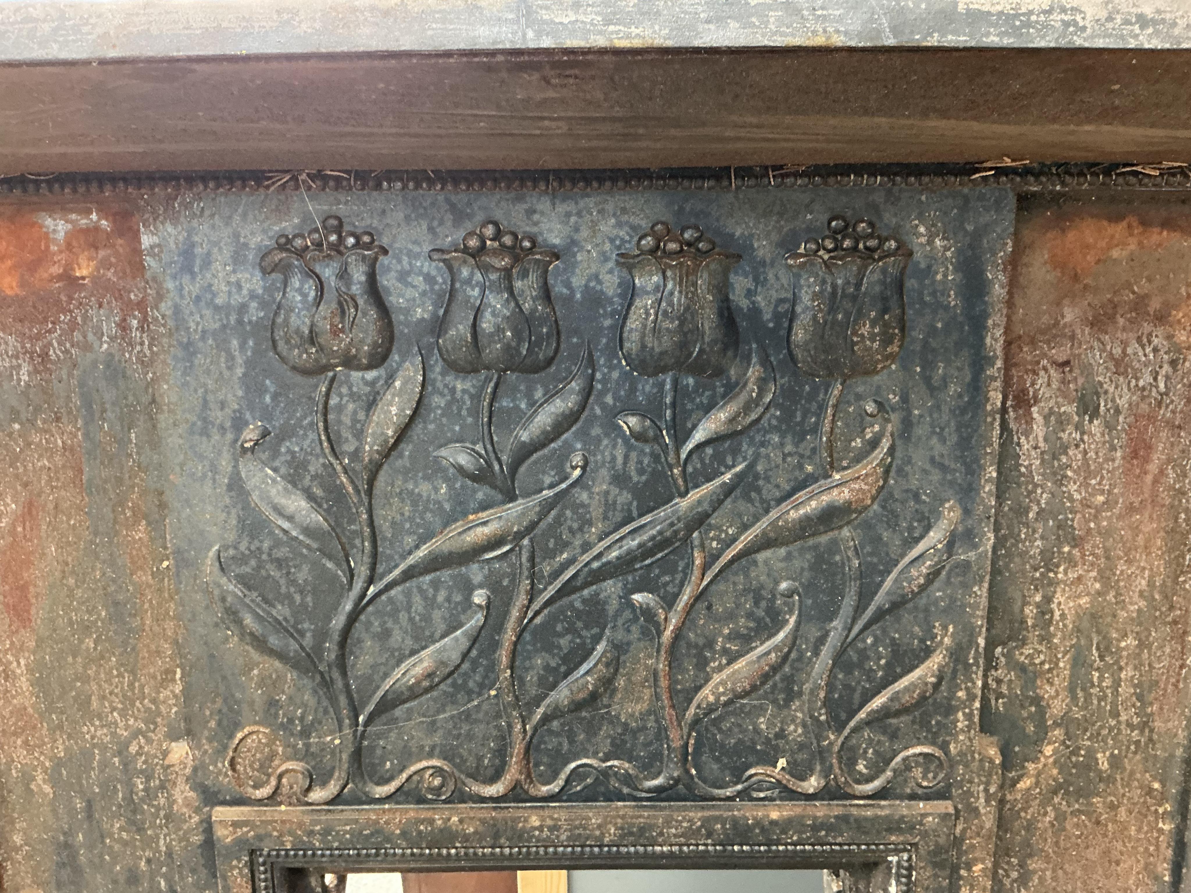 A late Victorian Art Nouveau cast iron fire surround, with tulip design, width 94cm, height 126cm